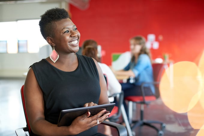 Confident female designer working on a digital tablet in red creative office space-1