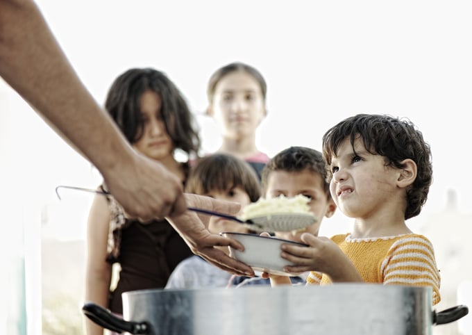 Hungry children in refugee camp, distribution of humanitarian food